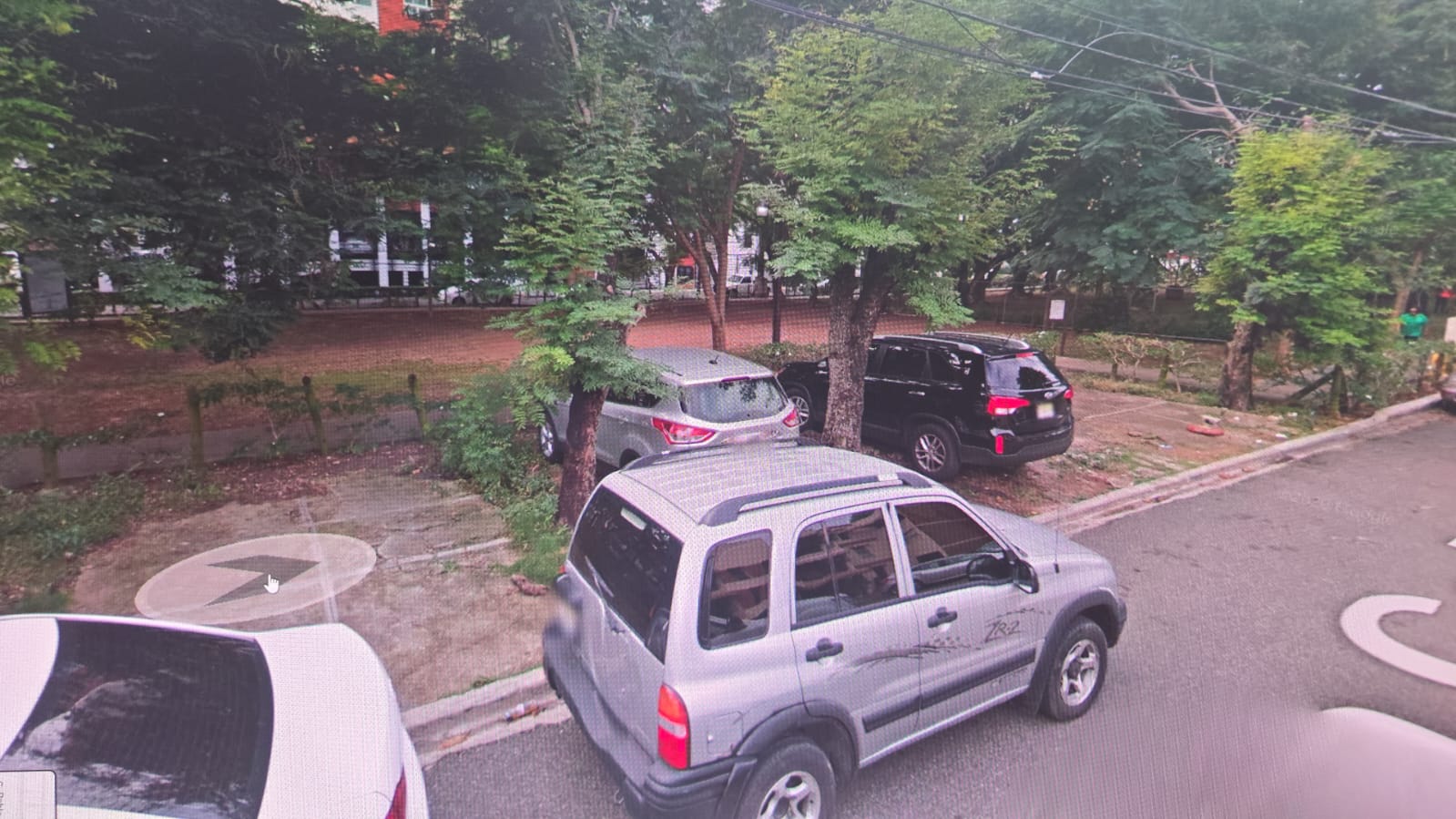 Fotografía anterior aportada por vecinos, con vehículos estacionados junto al parque